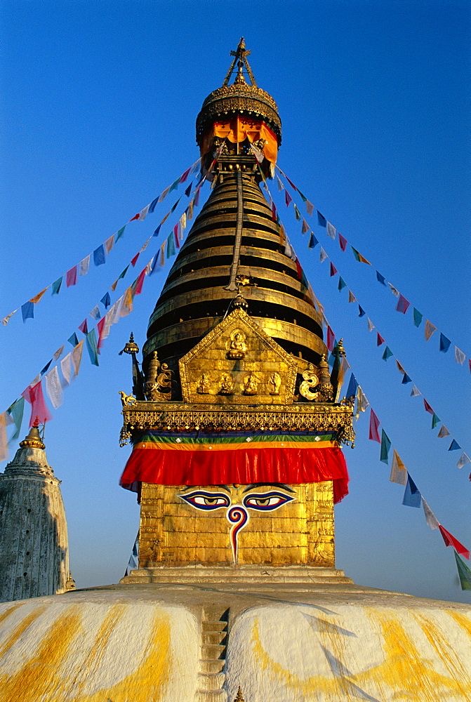 A stupa in Nepal with the eyes of the Buddha and prayer flags