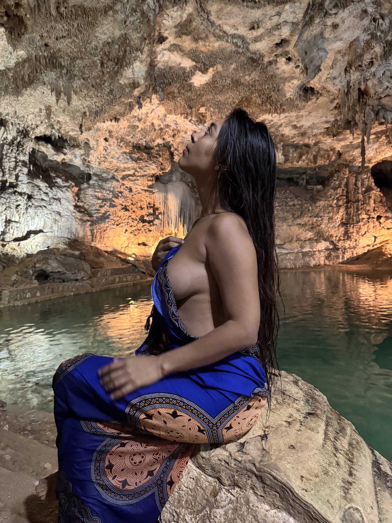 La Dra. Pamela Corona sentada a la orilla de un cenote en la Riviera Maya